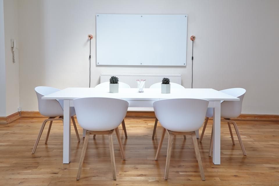 A meeting room with a long table and chairs