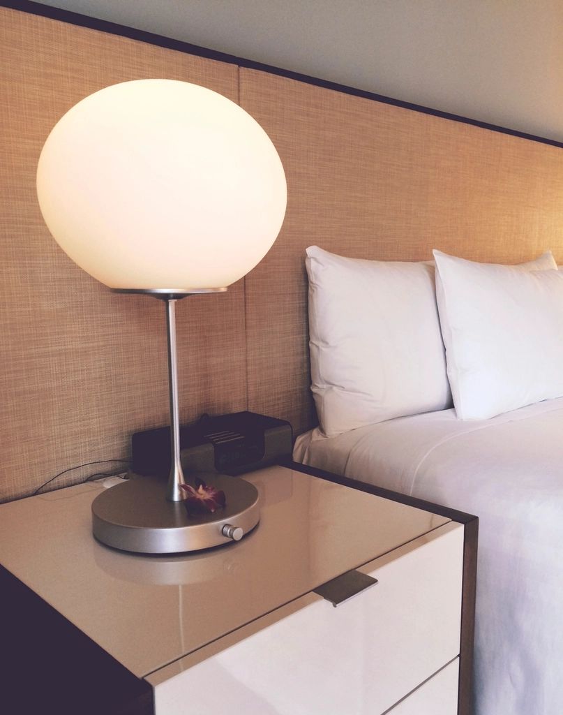 A guest room with a large bed and soft lighting